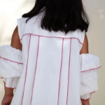 Picture of White And Fuchsia Piping With Shoulder Cut Dress For Girls